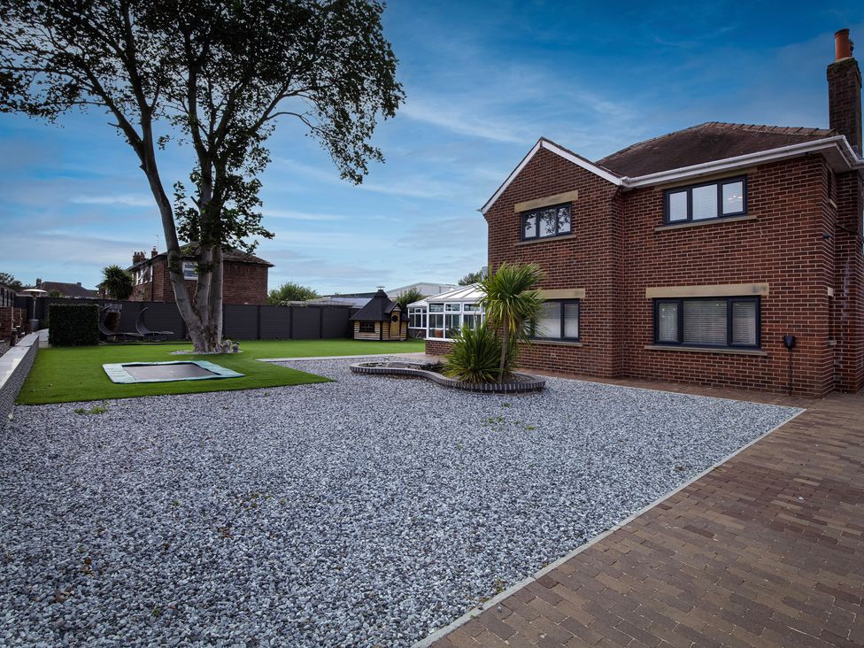A house with a garden featuring a trampoline and gravel at Wind Farm in 
