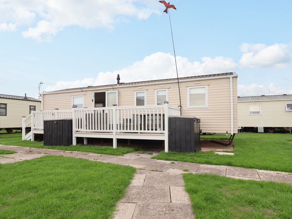 A mobile home with a deck and pathway at B54