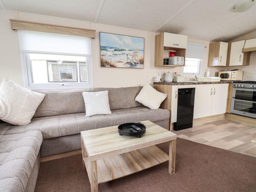 A living room with a sofa and kitchen area at B54
