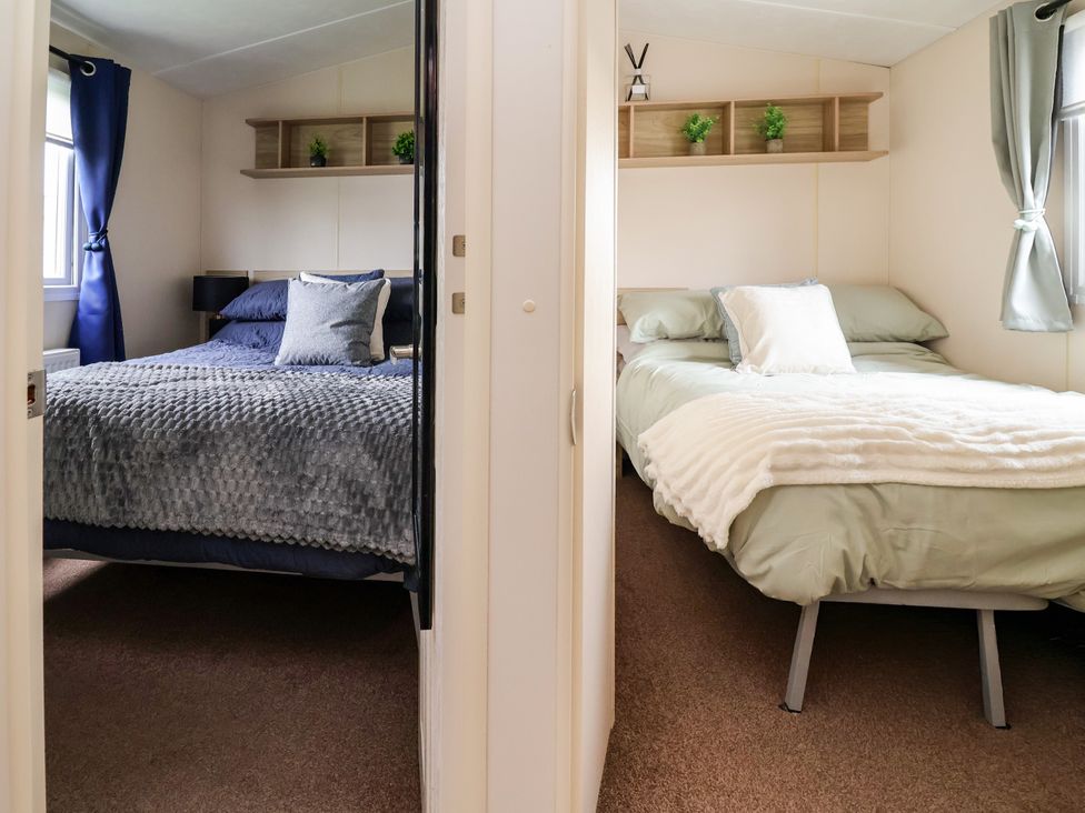 A bedroom with two beds and shelves at B54