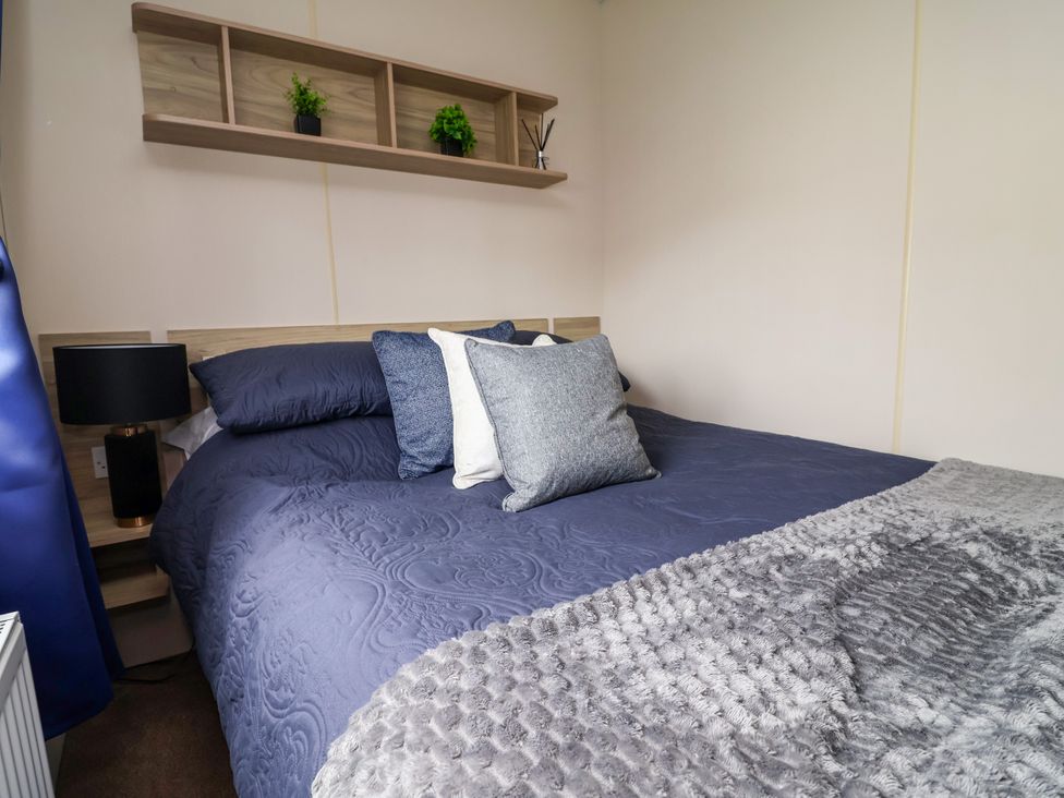 A bedroom with a bed and shelf at B54 
