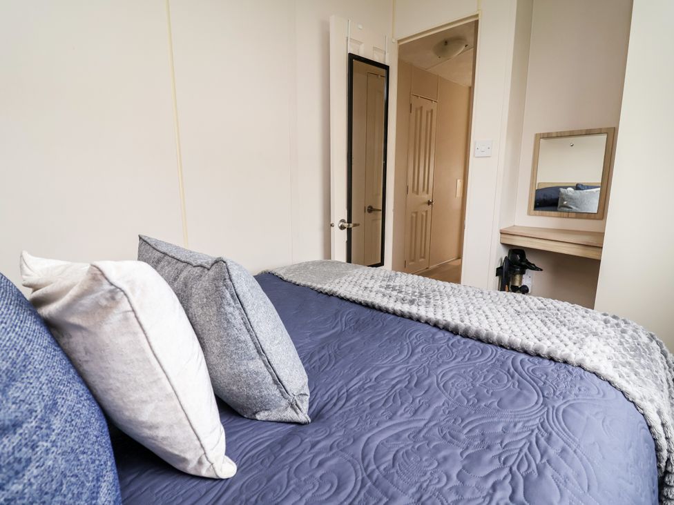 A bedroom featuring a bed with pillows, a mirror, and a door at B54 