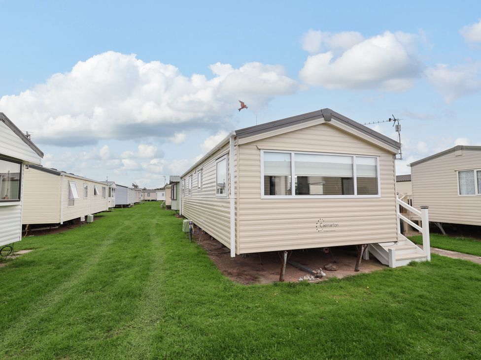 Mobile homes lined along a grassy pathway in an outdoor area at B54