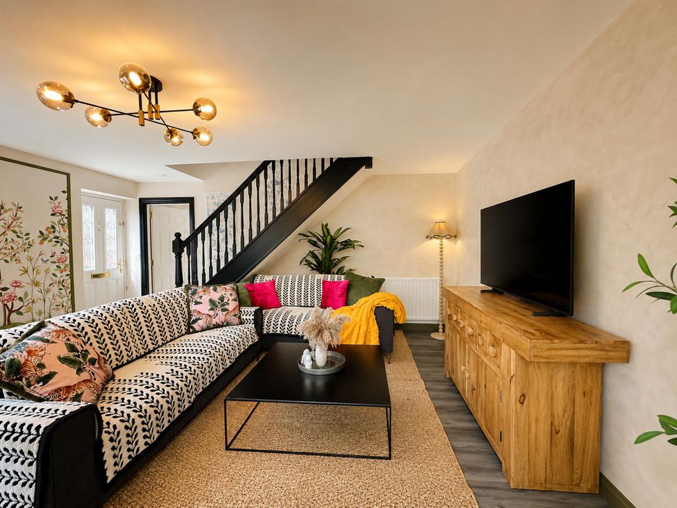 A living room with a sofa and coffee table at Muddy Boots – La Petite Mews in Kirby Stephen