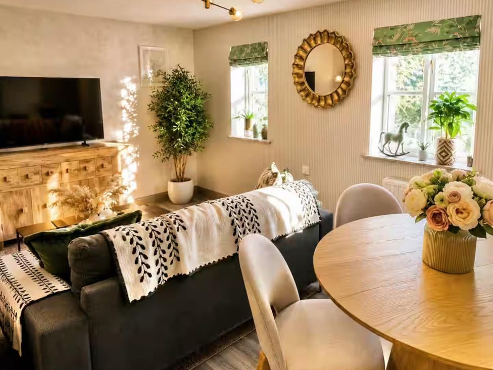 A living room with a television and sofa at Muddy Boots – La Petite Mews in Kirby Stephen