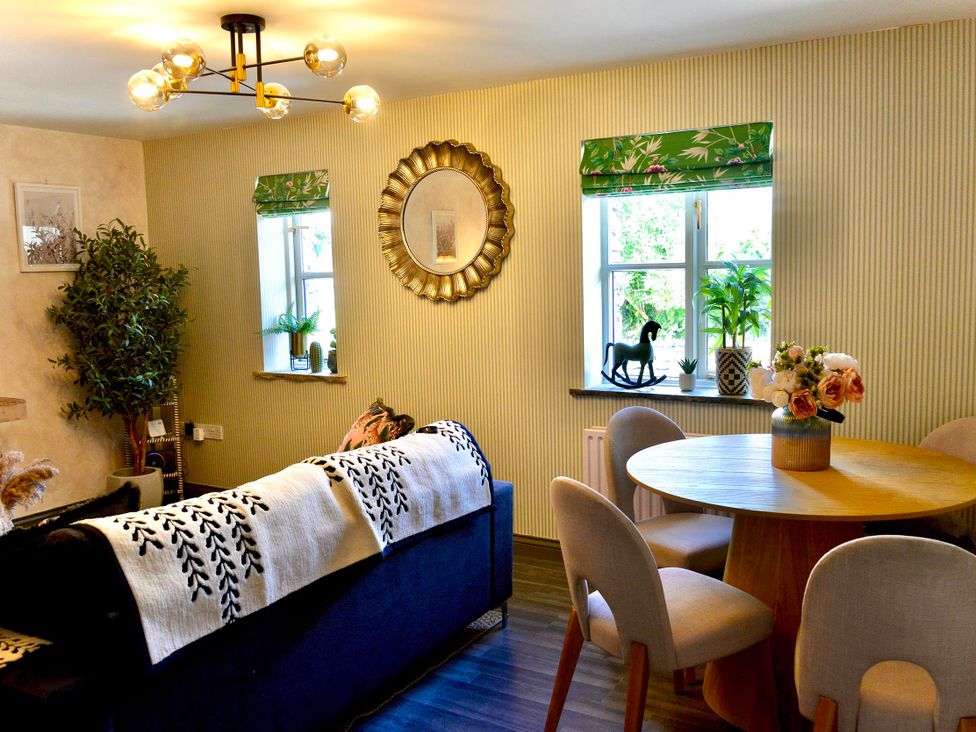 A living room with a table and chairs at Muddy Boots – La Petite Mews Kirby Stephen