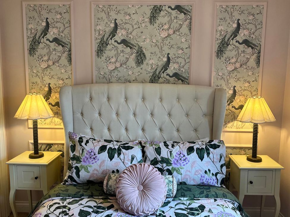 A bedroom with a bed and lamps at Muddy Boots – La Petite Mews in Kirby Stephen