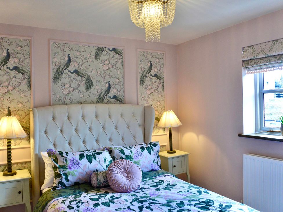 A bedroom with a bed and bedside tables at Muddy Boots – La Petite Mews, Kirby Stephen