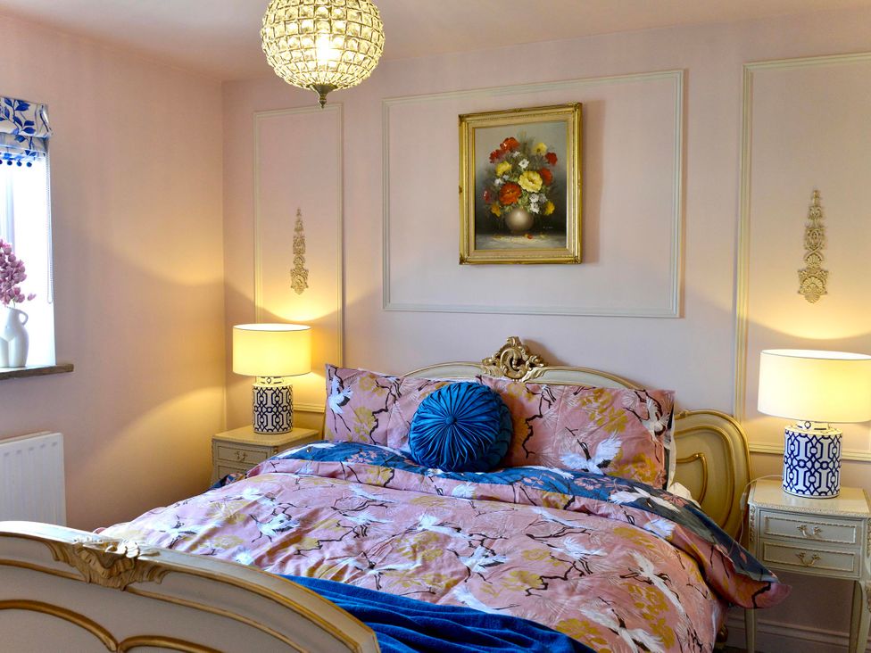 A bedroom with a bed and lamps at Muddy Boots – La Petite Mews in Kirby Stephen