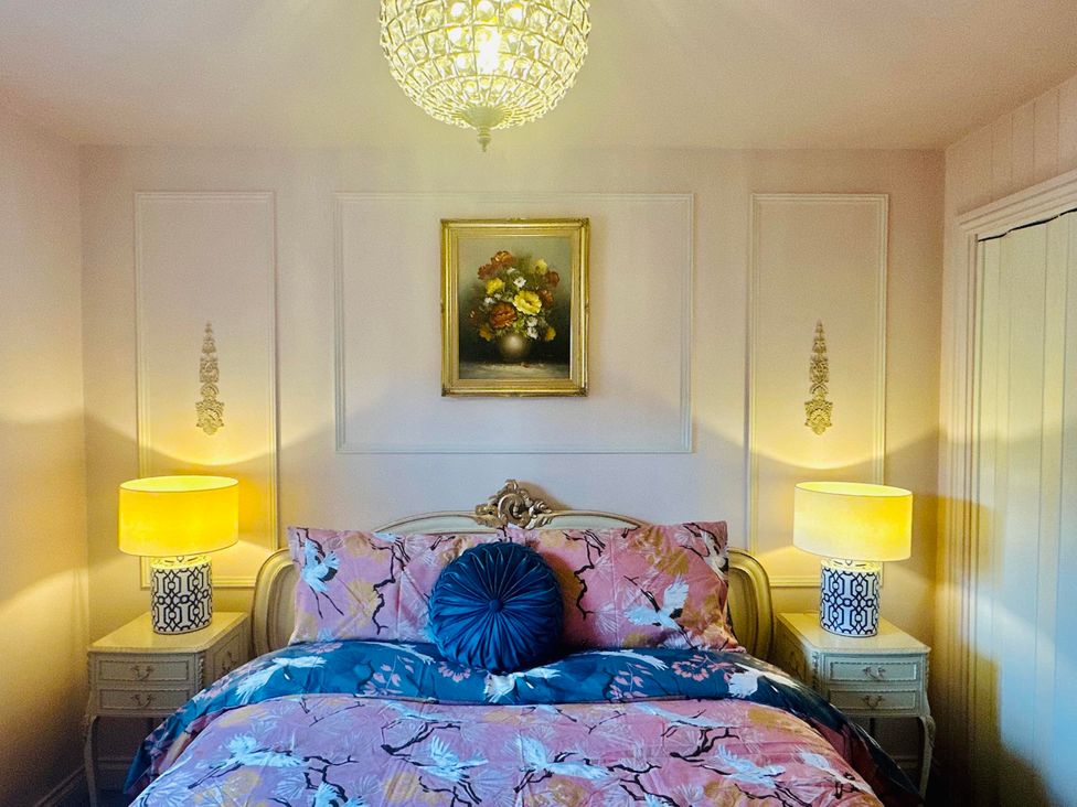 A bedroom with a bed and nightstands at Muddy Boots – La Petite Mews Kirby Stephen
