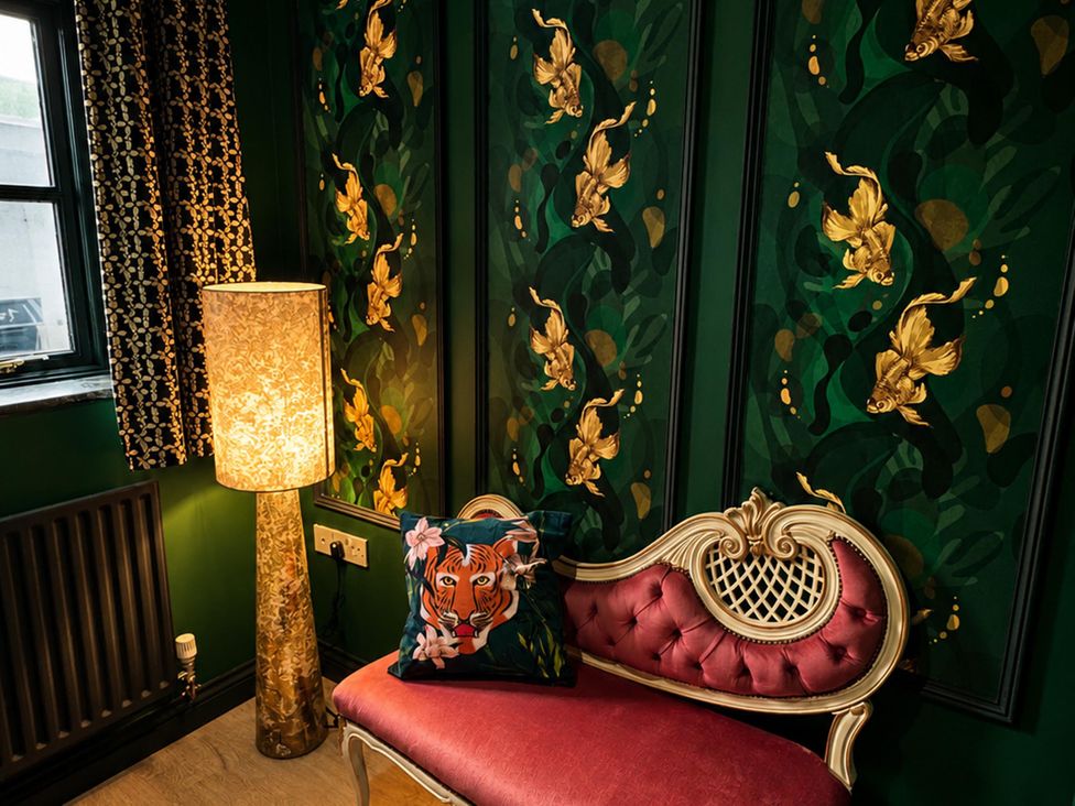 A sitting room with a sofa and lamp at Muddy Boots – La Petite Mews, Kirby Stephen