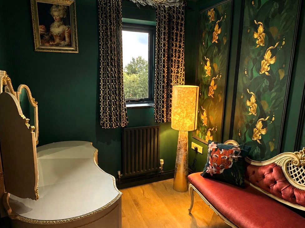 A sitting room with a table and a chair at Muddy Boots – La Petite Mews in Kirby Stephen
