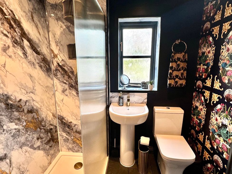 A bathroom with a shower, sink, and toilet at Muddy Boots – La Petite Mews in Kirby Stephen