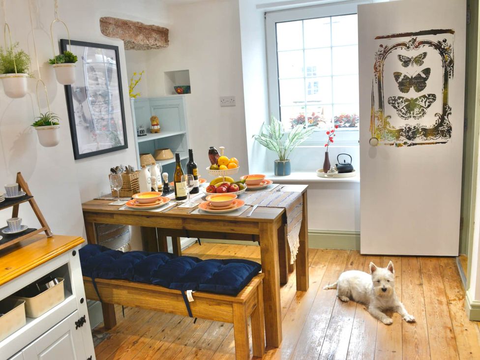A dining room with a table set for meals at Muddy Boots – Arcade Royale in Kirby Stephen