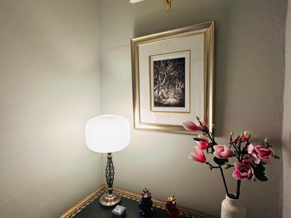 A table with lamp and picture at Muddy Boots – Arcade Royale in Kirby Stephen