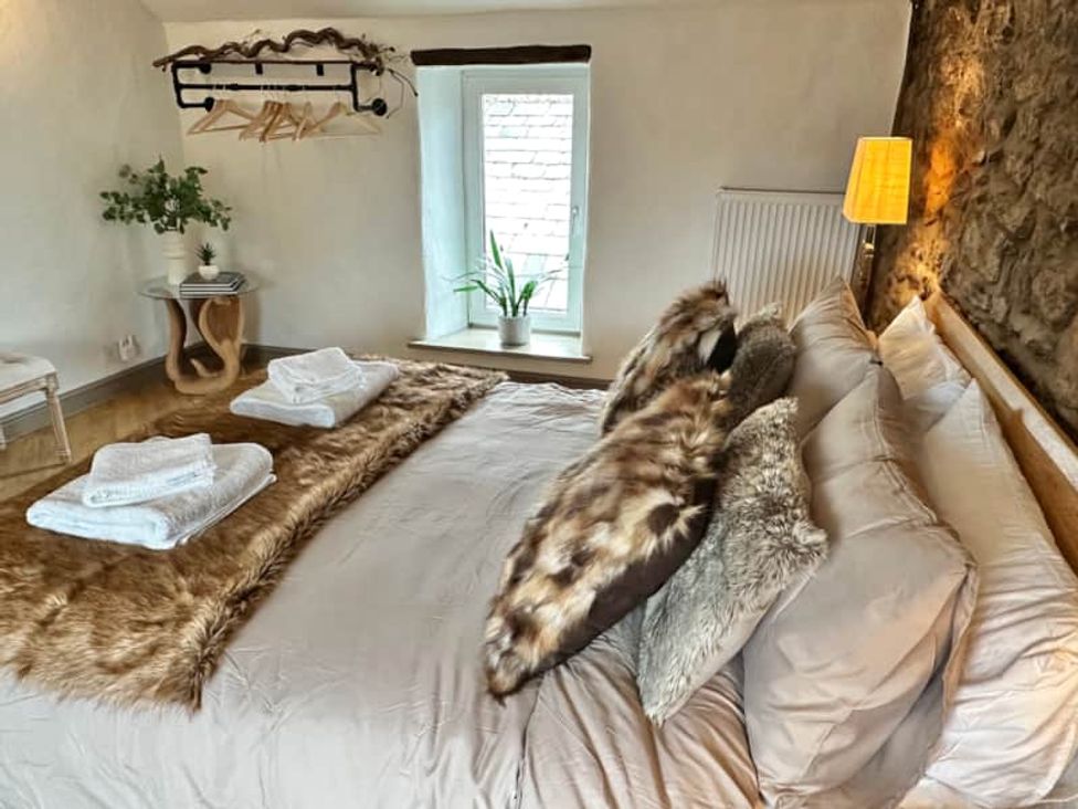A bedroom with a bed and pillows at Muddy Boots – Arcade Royale in Kirby Stephen