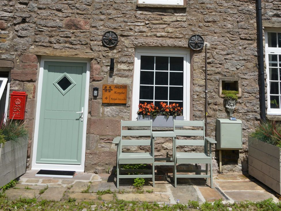 A door and seating area outside Muddy Boots – Arcade Royale in Kirby Stephen