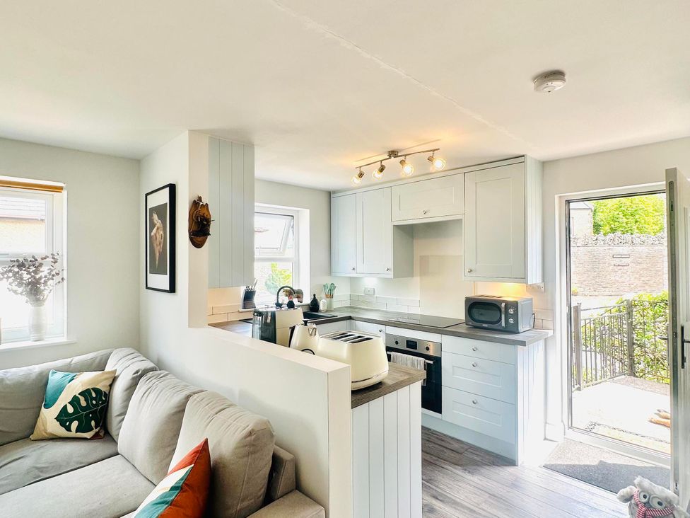 A kitchen with a sofa and appliances at Muddy Boots – Scarpa in Kirkby Stephen