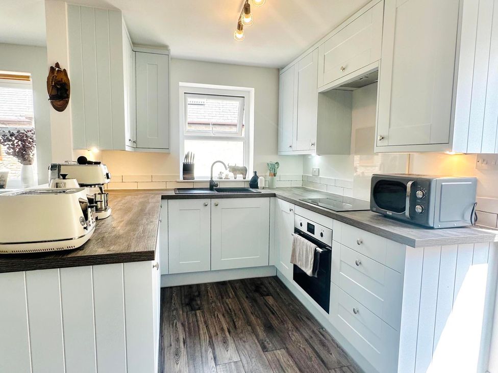 A kitchen with cabinets and appliances at Muddy Boots – Scarpa in Kirkby Stephen