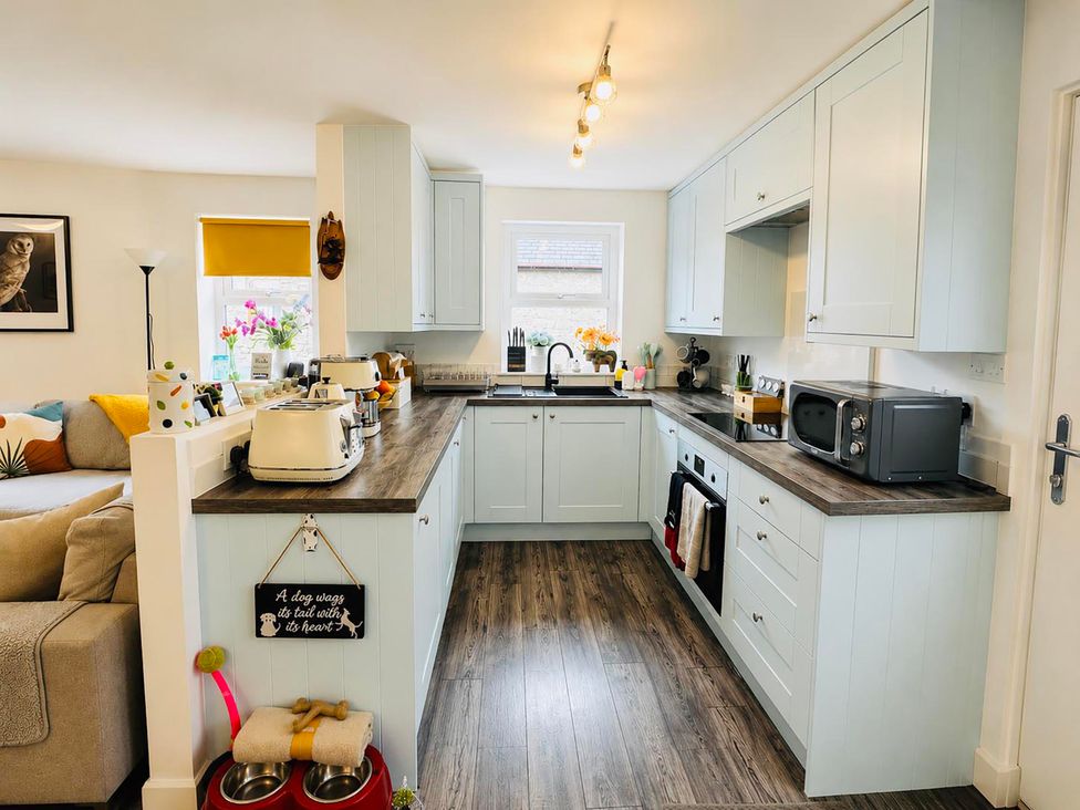 A kitchen with countertop, appliances and shelving at Muddy Boots – Scarpa in Kirkby Stephen