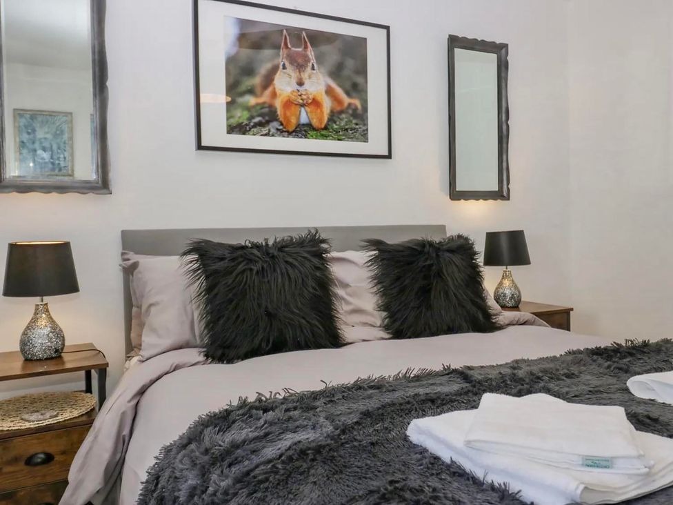 A bedroom with a bed and decorative pillows at Muddy Boots – Scarpa in Kirkby Stephen
