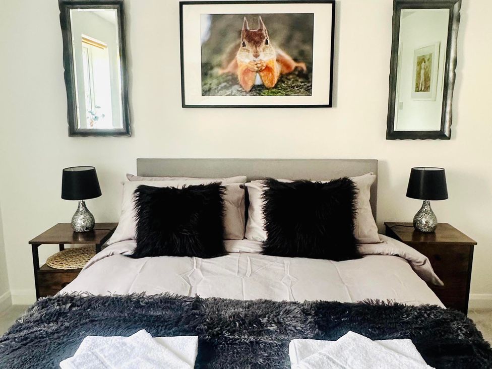 A bedroom with a bed and bedside tables at Muddy Boots – Scarpa in Kirkby Stephen