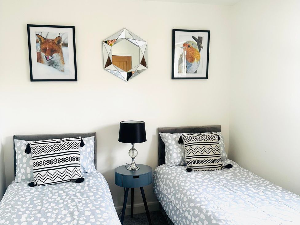 A bedroom with two beds and wall art at Muddy Boots – Scarpa, Kirkby Stephen