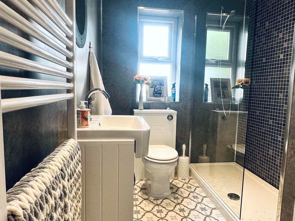 A bathroom featuring a shower, toilet, and sink at Muddy Boots – Scarpa in Kirkby Stephen