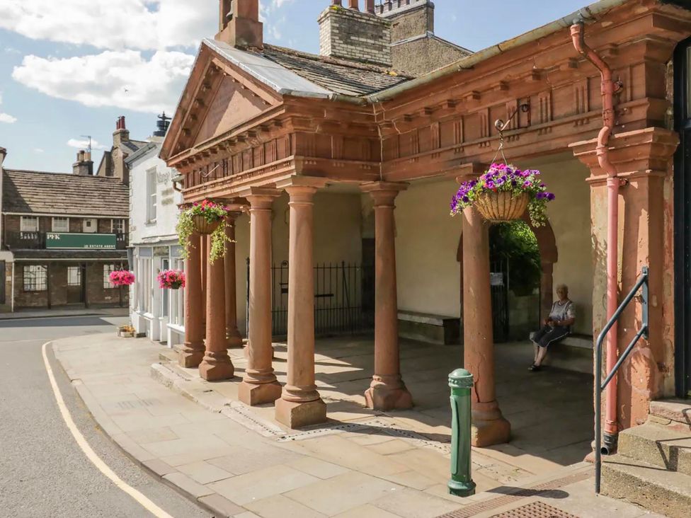 An outdoor area with columns and flower baskets at Muddy Boots – Scarpa in Kirkby Stephen