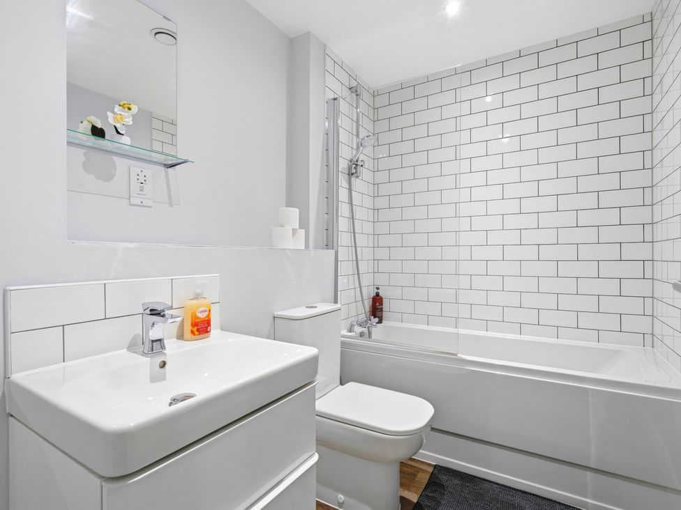 A bathroom with a sink, toilet, and bathtub at Apartment 56 in Birmingham