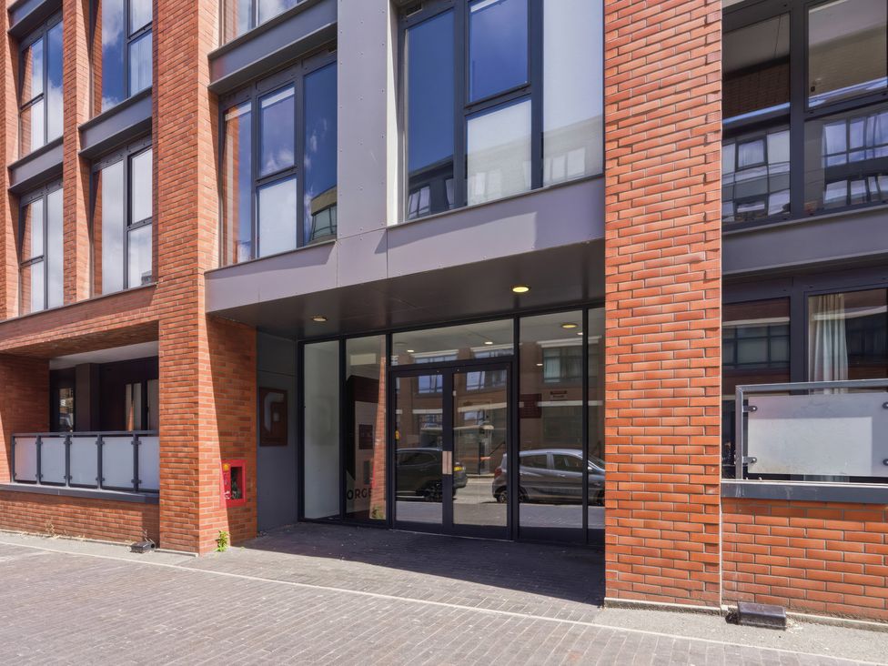 An entrance to a building with windows and cars parked at Apartment 56 Birmingham