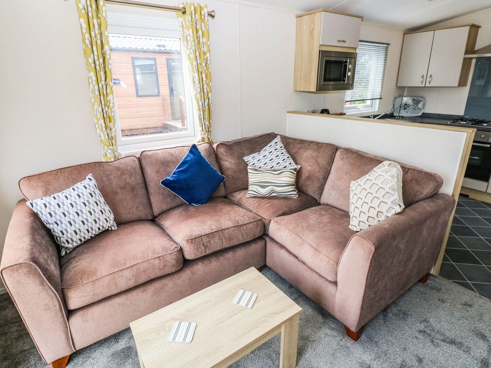 A living room with a sofa and coffee table at Seascape in Haverfordwest