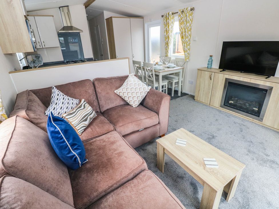 A living room with a sofa and dining area at Seascape in Haverfordwest