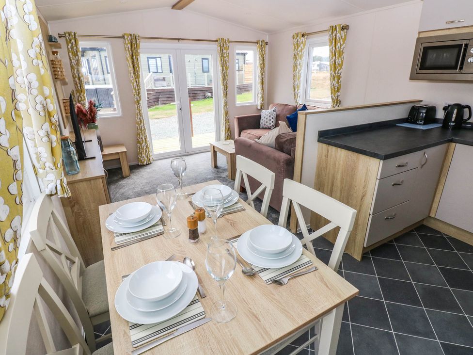 A living room with a dining table and a sofa at Seascape in Haverfordwest