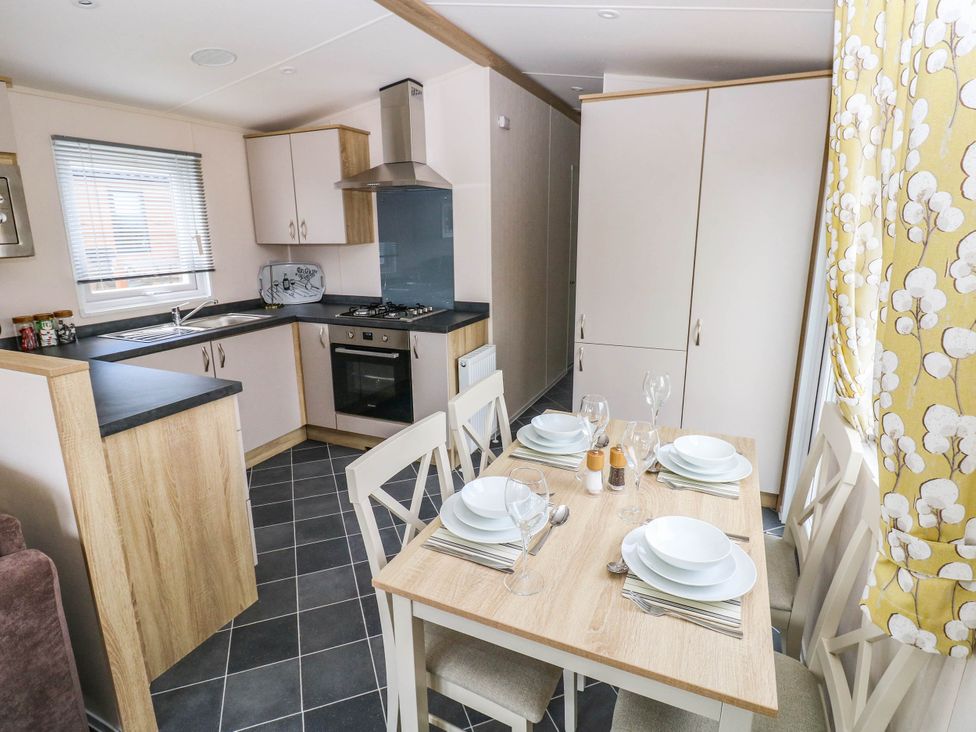A kitchen with a dining table and chairs at Seascape in Haverfordwest