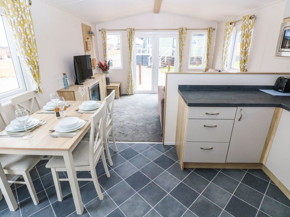 A dining room with a table set for meals at Seascape in Haverfordwest