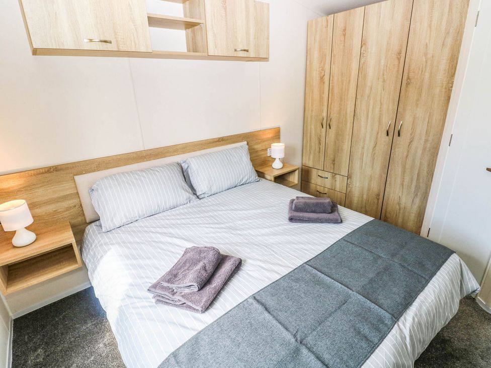 A bedroom with a bed and wardrobe at Seascape in Haverfordwest