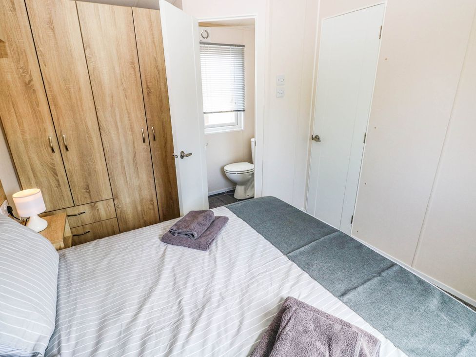 A bedroom with a wardrobe and a bathroom in view at Seascape in Haverfordwest