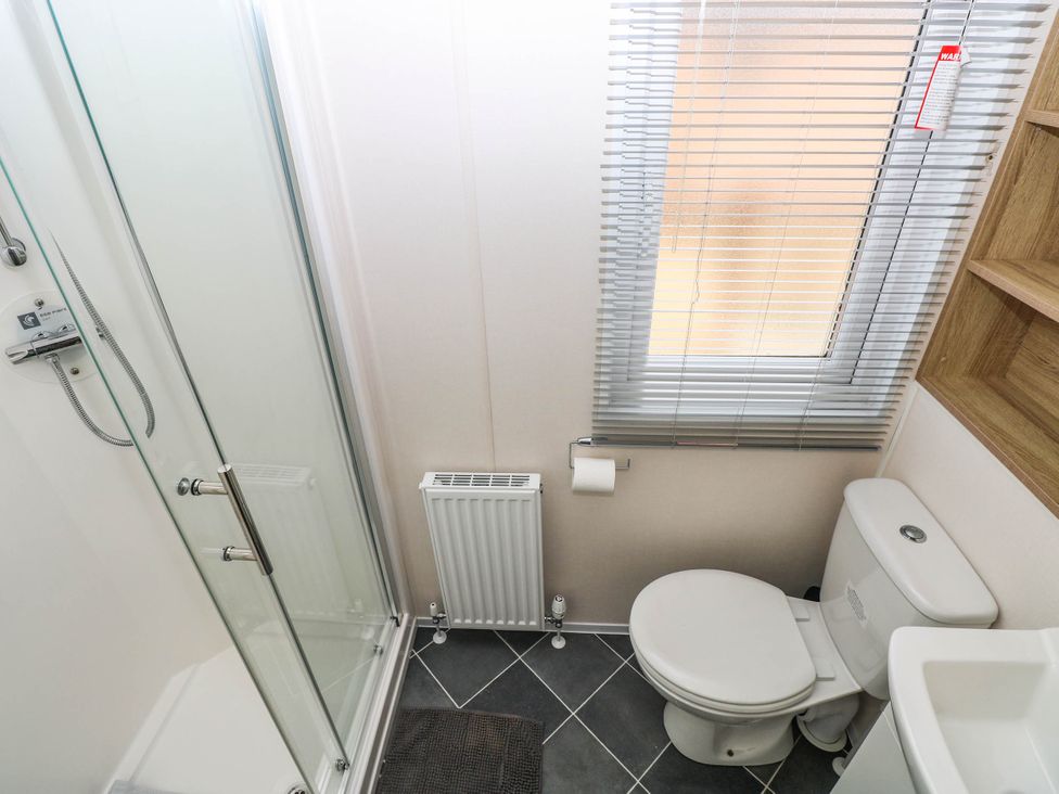 A bathroom with shower, toilet, and radiator at Seascape in Haverfordwest