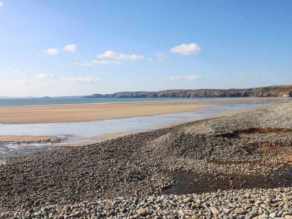 A beach with rocks and water at Seascape in Haverfordwest