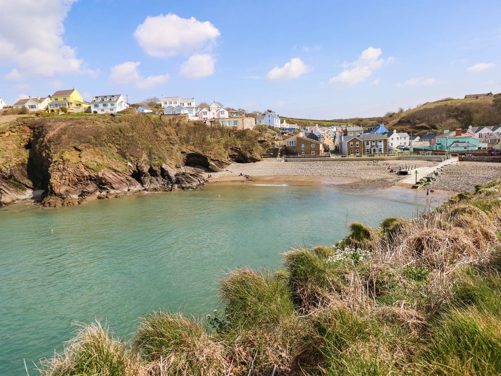 A beach with water and houses at Seascape in Haverfordwest