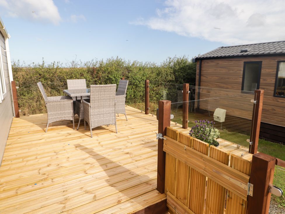 An outdoor area with a table and chairs at Seascape near Little Haven