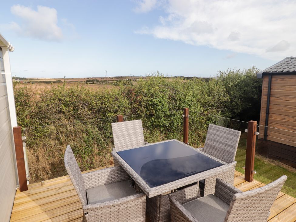 An outdoor seating area with a table and chairs at Seascape near Little Haven