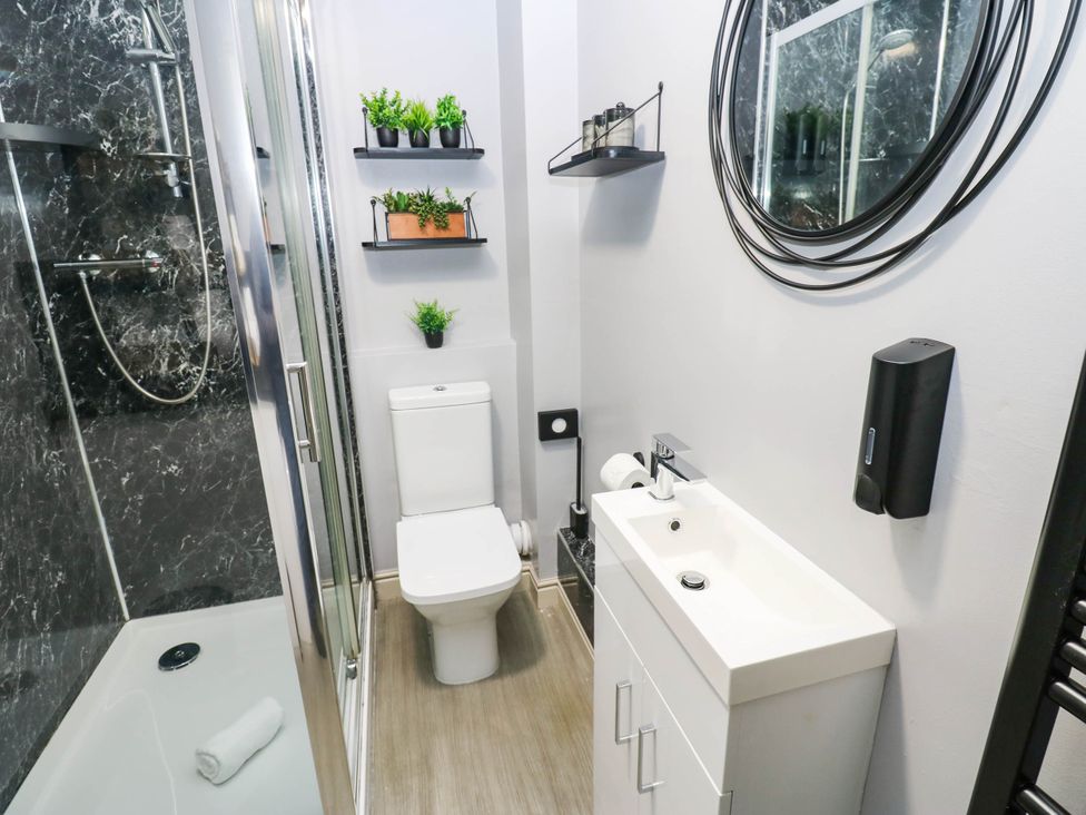 A bathroom with shower, toilet, sink and mirror at Sands Green in Appleby-In-Westmorland