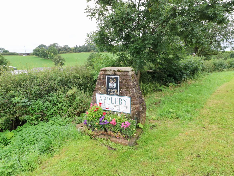A sign for Appleby with flowers at the base at Sands Green in Appleby-In-Westmorland
