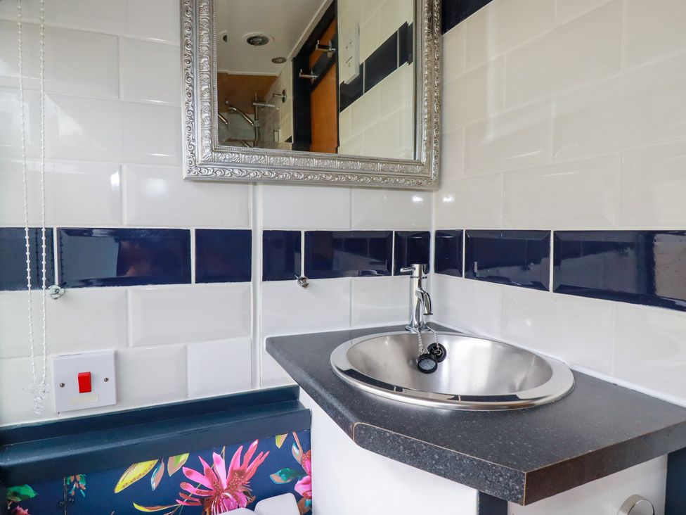A bathroom with a sink and mirror at Honey Bee Bus in Menheniot
