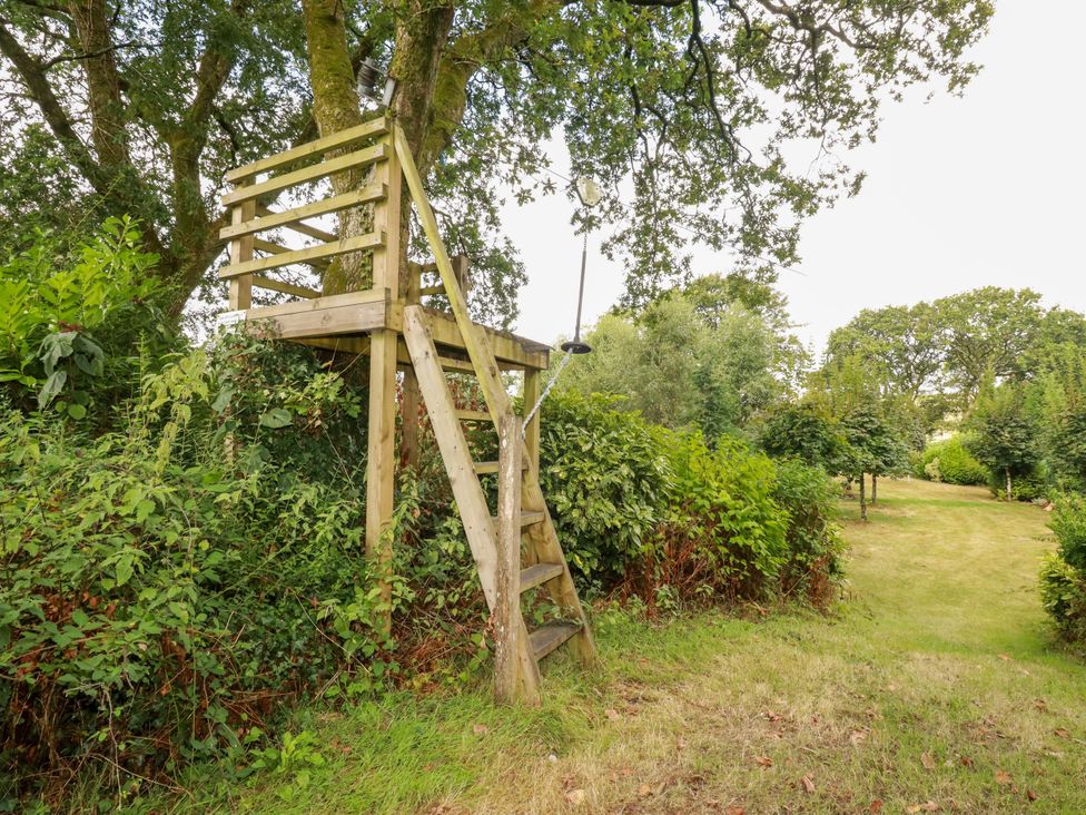 A wooden watchtower in a garden at Honey Bee Bus in Menheniot