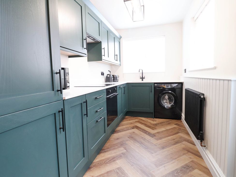 A kitchen with cabinets and a washing machine at 9 North Street Chester