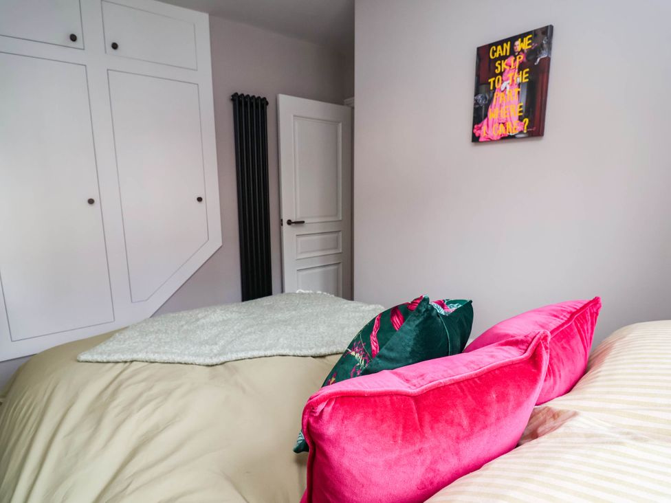 A bedroom with a bed and colorful cushions at 9 North Street Chester