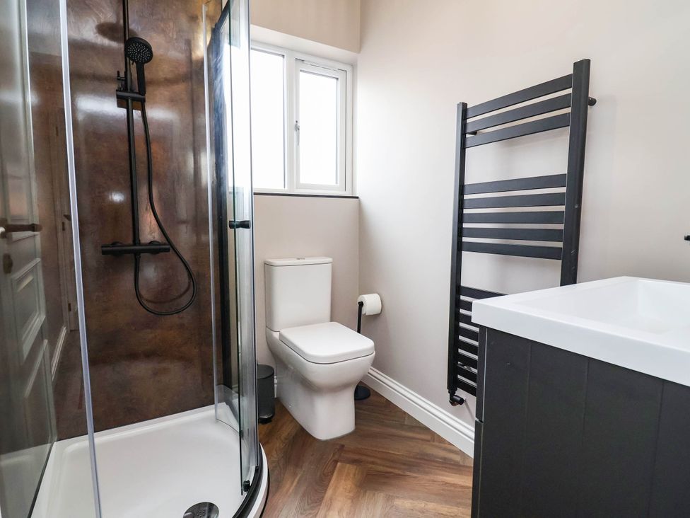 A bathroom featuring a shower, toilet, sink, and towel radiator at 9 North Street Chester